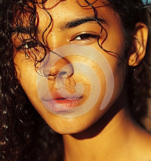 Young pretty african curly girl on sunset on beach looking, lifestyle people concept