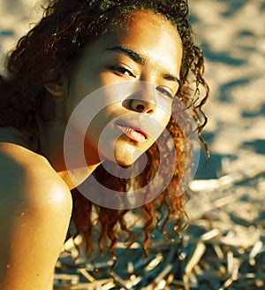 Young pretty african curly girl on sunset on beach looking, lifestyle people concept