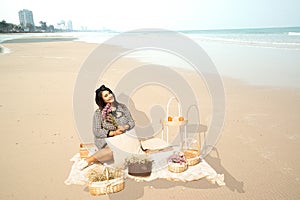 Young pretty Asian fat woman sitting on clothes on the beach.