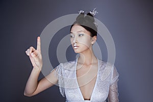 Young pretty asian futuristic woman pressing an imaginary button, empty space for buttons