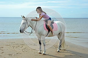 Young pretty asian woman riding white horse