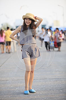 Young and pretty asian woman wearing straw hat standing and post