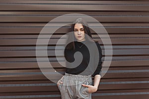 Young pretty beautiful woman in black vintage sweater in fashionable gray checkered pants