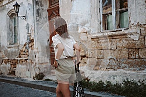 Young pretty beautiful woman is walking outdoors in the ancient town enjoys the sights