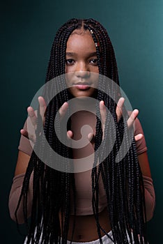 Young pretty black woman showing her hands through her braided hair