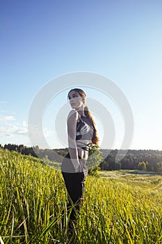 young pretty blond caucasian girl resting in green field at summer, lifestyle people concept