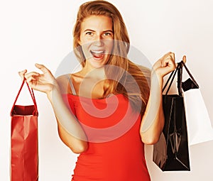 Young pretty blond woman with bags on winter sale in red dress i