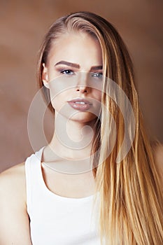 Young pretty blond woman with fresh natural makeup posing cheerful on browm background, lifestyle people concept