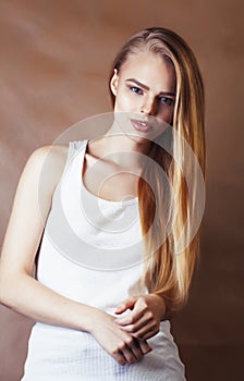 Young pretty blond woman with fresh natural makeup posing cheerful on browm background, lifestyle people concept