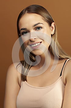 Young pretty blond woman with fresh natural makeup posing cheerful on browm background, lifestyle people concept