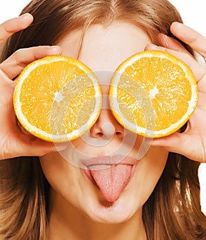 Young pretty blond woman with half oranges close