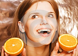 Young pretty blond woman with half oranges close up on white bright teenage smiling