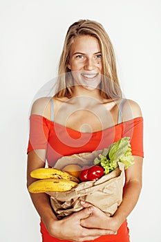 Young pretty blond woman at shopping with food in paper bag isolated on white smiling bright, lifestyle people concept