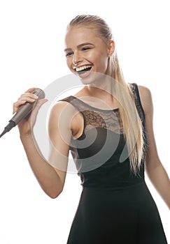 Young pretty blond woman singing in microphone