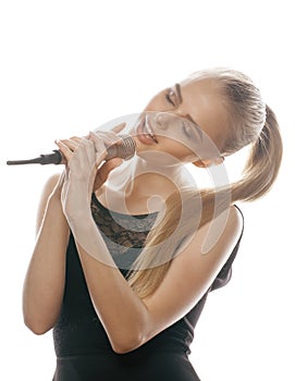 Young pretty blond woman singing in microphone isolated close up karaoke