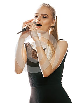 Young pretty blond woman singing in microphone isolated close up karaoke