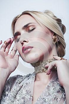 Young pretty blond woman wearing lot of luxury rich jewelry and fashion style makeup, lifestyle beauty people concept