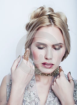 Young pretty blond woman wearing lot of luxury rich jewelry and fashion style makeup, lifestyle beauty people concept