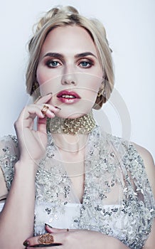 Young pretty blond woman wearing lot of luxury rich jewelry and fashion style makeup, lifestyle beauty people concept