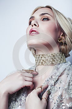 Young pretty blond woman wearing lot of luxury rich jewelry and fashion style makeup, lifestyle beauty people concept