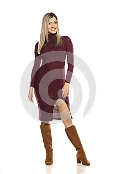 Young pretty blonde in a tight red dress and leather boots