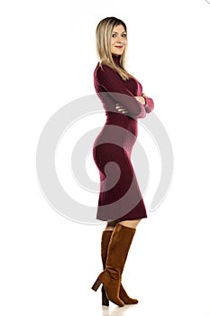 Young pretty blonde in a tight red dress and leather boots