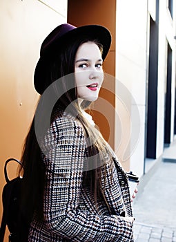 Young pretty brunette business woman posing against modern building in hat holding coffee, lifestyle people concept