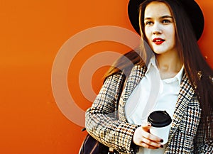 young pretty brunette business woman posing against modern building in hat holding coffee, lifestyle people concept