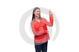 young pretty brunette caucasian model woman dressed in fashionable red shirt tells interesting news on white background