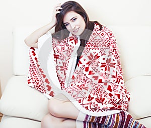 Young pretty brunette girl in Christmas ornament blanket getting warm on cold winter, freshness beauty concept