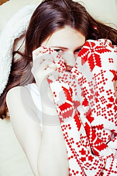 Young pretty brunette girl in Christmas ornament blanket getting warm on cold winter, freshness beauty concept