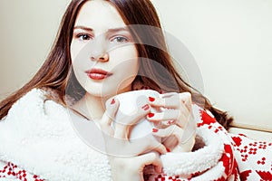 Young pretty brunette girl in Christmas ornament blanket getting warm on cold winter, freshness beauty concept