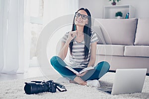 Young pretty brunette photographer freelancer with notebook and spectacles have great idea about businessplan while photo