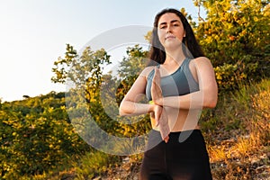 Young pretty brunette woman doing yoga in the Park or forest. The concept of fitness, yoga and sports