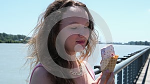 Young Pretty Brunette Woman eating an Ice Cream Cone on a Summer Street, Slow motion