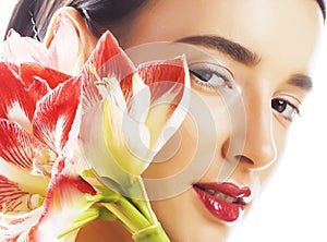 Young pretty brunette woman with red flower amaryllis close up i