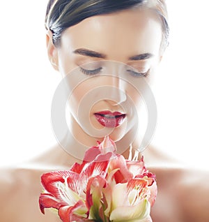 Young pretty brunette woman with red flower amaryllis close up isolated on white background. Fancy fashion makeup