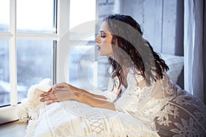 Young pretty brunette woman sitting at window at home at morning relaxing, lifestyle people concept
