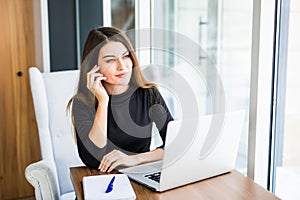 Young pretty business woman with notebook in the bright modern office