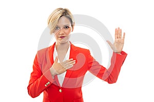 Young pretty business woman showing oath gesture