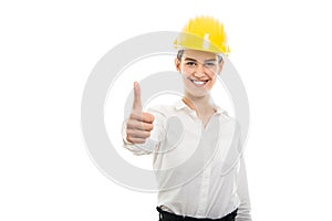 Young pretty business woman showing thumb up gesture wearing helmet