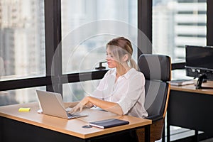 Young pretty business woman working on laptop computer or notebook in the office