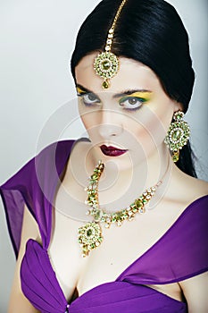 Young pretty caucasian woman like indian in ethnic jewelry close