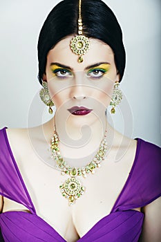 Young pretty caucasian woman like indian in ethnic jewelry close