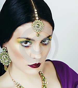 young pretty caucasian woman like indian in ethnic jewelry closeup on white, bridal bright makeup fashion people