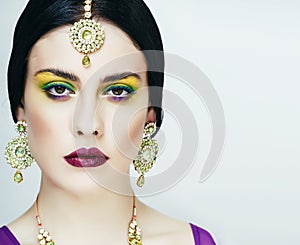 young pretty caucasian woman like indian in ethnic jewelry closeup on white, bridal bright makeup fashion people