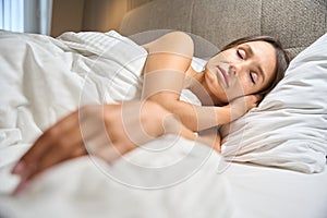 Young pretty caucasian woman sleeping on bed in hotel room at morning time