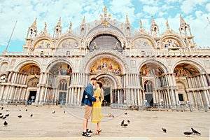 young pretty couple kissing in front of saint marks basilica venice italy