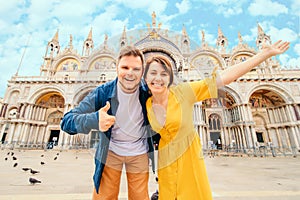 young pretty couple posing in front of saint marks basilica venice italy