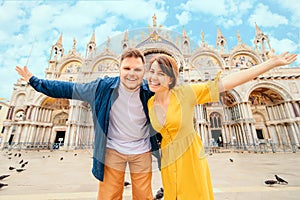 young pretty couple posing in front of saint marks basilica venice italy